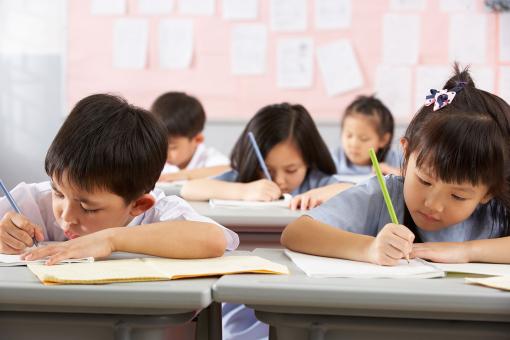 Students Working At Desks In Chinese School Classroom