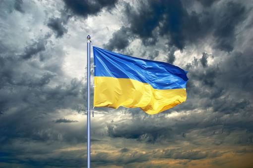 Ukrainian flag on black storm cloud sky