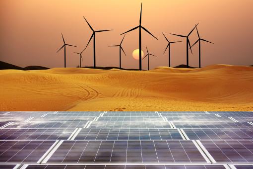 Renewable energy with windmills and solar panels in desert at sunset