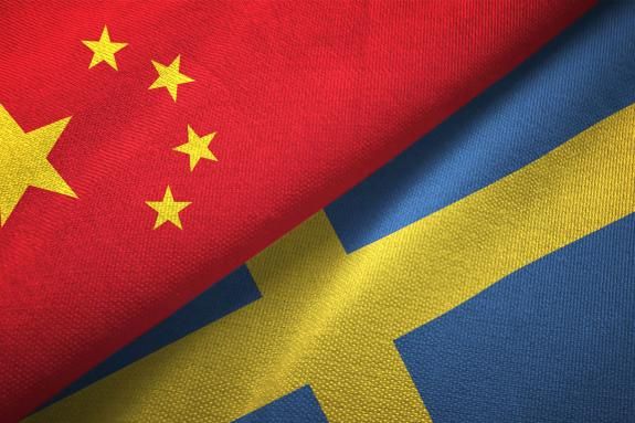 Sweden and China two flags together. Textile cloth fabric texture.